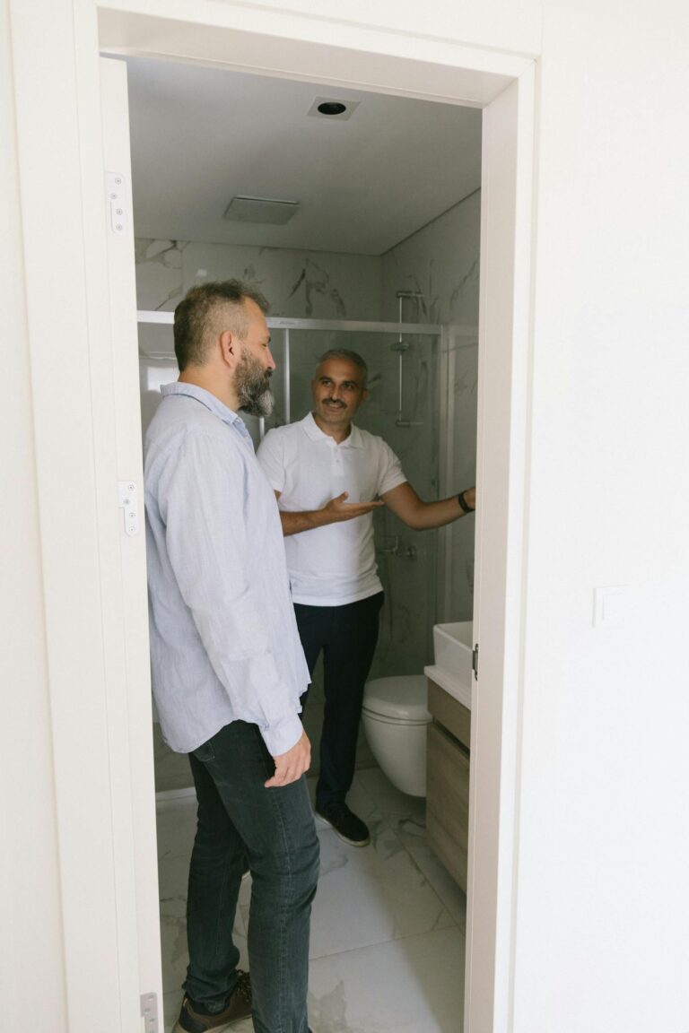 Real estate agent showcases bathroom features in Istanbul apartment.